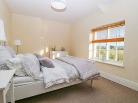 A bedroom with a bed, lamp, and window at Tuft House in Hovingham