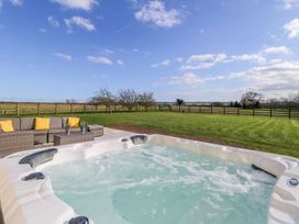 An outdoor area with a hot tub and seating at Tuft House in Hovingham