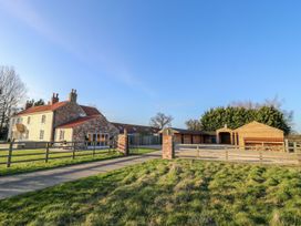 A house and barn in a yard at Tuft House in Hovingham