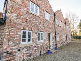 An exterior view of a brick house with windows and a door at Tuft House in Hovingham