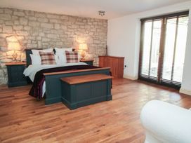 A bedroom with a bed and wooden furniture at Tuft House in Hovingham