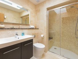 A bathroom with a shower, sink, and toilet at The Chimney in Bamburgh