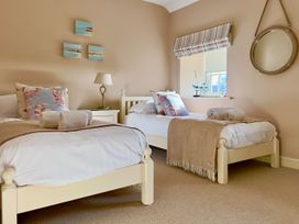 A bedroom with two beds and a nightstand at The Chimney in Bamburgh