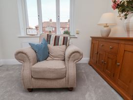A living room with an armchair and sideboard at Helmsley Cottage in Helmsley