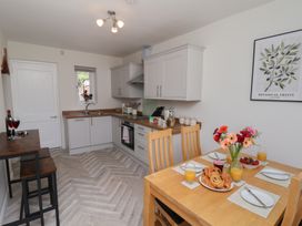 A kitchen with a table, chairs, and food items at Helmsley Cottage in Helmsley