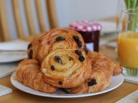 A plate of pastries with a jar and a glass of juice at Helmsley Cottage, Helmsley
