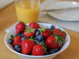 A bowl of strawberries and blueberries with juice at Helmsley Cottage in Helmsley