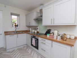 A kitchen with cabinets and appliances at Helmsley Cottage Helmsley