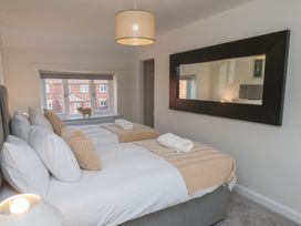 A bedroom with two beds and a window at Helmsley Cottage in Helmsley