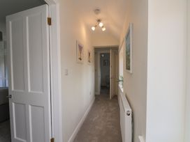 A hallway with a light fixture and wall art at Helmsley Cottage in Helmsley