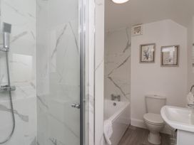 A bathroom with a shower, bathtub, and sink at Helmsley Cottage in Helmsley