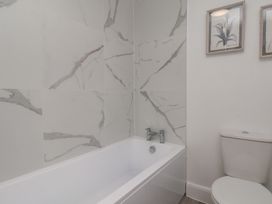 A bathroom with a bathtub and toilet at Helmsley Cottage in Helmsley