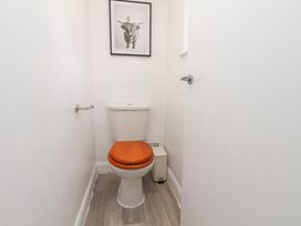 A bathroom with a toilet and framed art at Helmsley Cottage in Helmsley