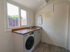 A laundry room with a washing machine and sink at Helmsley Cottage in Helmsley