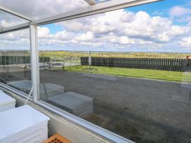 A view from a conservatory showing a grassy area and a wooden fence at Marie's Country Home in Ardee, County Louth