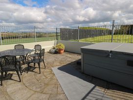An outdoor area with a table, chairs, hot tub, and potted plant at Marie's Country Home in Ardee, County Louth