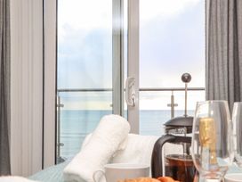 A balcony with sea view and breakfast items at Ty Bryn in Marazion
