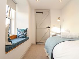 A bedroom with a bed and a window seat at Ty Bryn in Marazion