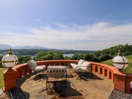 An outdoor patio with seating overlooking water at Apartment 1, Bryn Mel Manor Menai Bridge