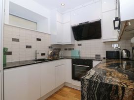 A kitchen with cabinets and appliances at Apartment 1, Bryn Mel Manor in Menai Bridge
