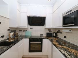 A kitchen with cabinets and appliances at Apartment 1, Bryn Mel Manor in Menai Bridge