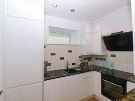 A kitchen with cabinets, sink, and oven at Apartment 1, Bryn Mel Manor Menai Bridge