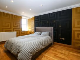 A bedroom with a bed and window at Apartment 1, Bryn Mel Manor in Menai Bridge