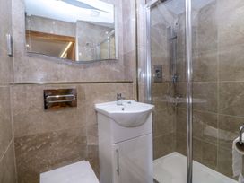 A bathroom with a shower, sink, toilet, and mirror at Apartment 1, Bryn Mel Manor Menai Bridge