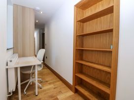 A workspace area with a desk and bookshelf at Apartment 1, Bryn Mel Manor Menai Bridge