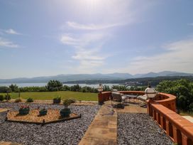 A patio area overlooking a lake and mountains at Apartment 1, Bryn Mel Manor Menai Bridge