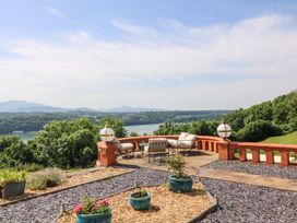 An outdoor patio with seating area overlooking a body of water at Apartment 1, Bryn Mel Manor Menai Bridge