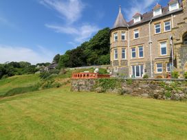 A garden with a lawn and a building at Apartment 1, Bryn Mel Manor in Menai Bridge
