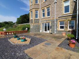 A patio area with planters and stone path at Apartment 1, Bryn Mel Manor in Menai Bridge
