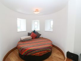 A bedroom with a round bed and windows at Apartment 1, Bryn Mel Manor Menai Bridge