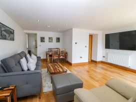 A living room with a sofa and dining table at Apartment 1, Bryn Mel Manor in Menai Bridge