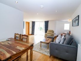 A living room with a dining table and sofa at Apartment 1, Bryn Mel Manor in Menai Bridge