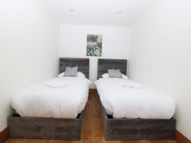 A bedroom with two single beds and a painting at Apartment 1, Bryn Mel Manor Menai Bridge