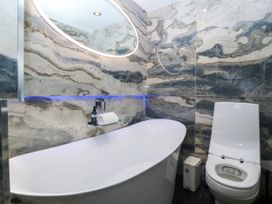 A bathroom featuring a bathtub and toilet at Apartment 1, Bryn Mel Manor in Menai Bridge