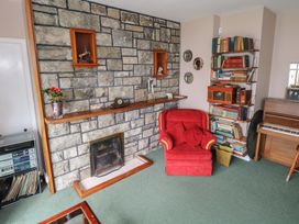 A living room with a fireplace and bookshelf at Sweetbriar Lodge in Castlerea