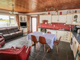 A kitchen with a dining area and couch at Sweetbriar Lodge in Castlerea