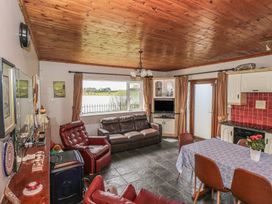 A living room with a sofa, armchairs, and a dining table at Sweetbriar Lodge, Castlerea