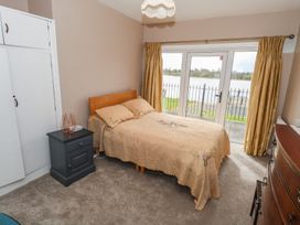 A bedroom with a bed and a view of the water at Sweetbriar Lodge in Castlerea