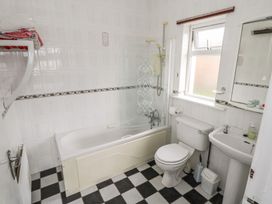 A bathroom with bathtub, toilet, sink, and towel rack at Sweetbriar Lodge in Castlerea