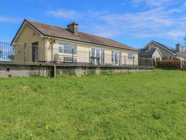 A house with a fence and grass in front at Sweetbriar Lodge Castlerea