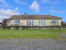 A house with a front porch and fence at Sweetbriar Lodge in Castlerea