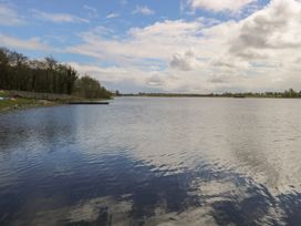 A lake with trees and clouds at Sweetbriar Lodge in Castlerea