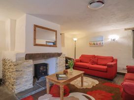 A living room featuring a fireplace, sofa, and coffee table at Cider Cottage in Hawkchurch