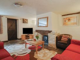 A living room with a television, sofa, and coffee table at Cider Cottage, Hawkchurch