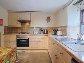 A kitchen with appliances and cabinets at Cider Cottage in Hawkchurch