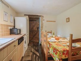 A kitchen with a table and chairs at Cider Cottage in Hawkchurch